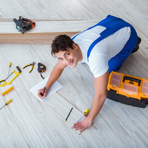 flooring installer measuring laminate flooring plank